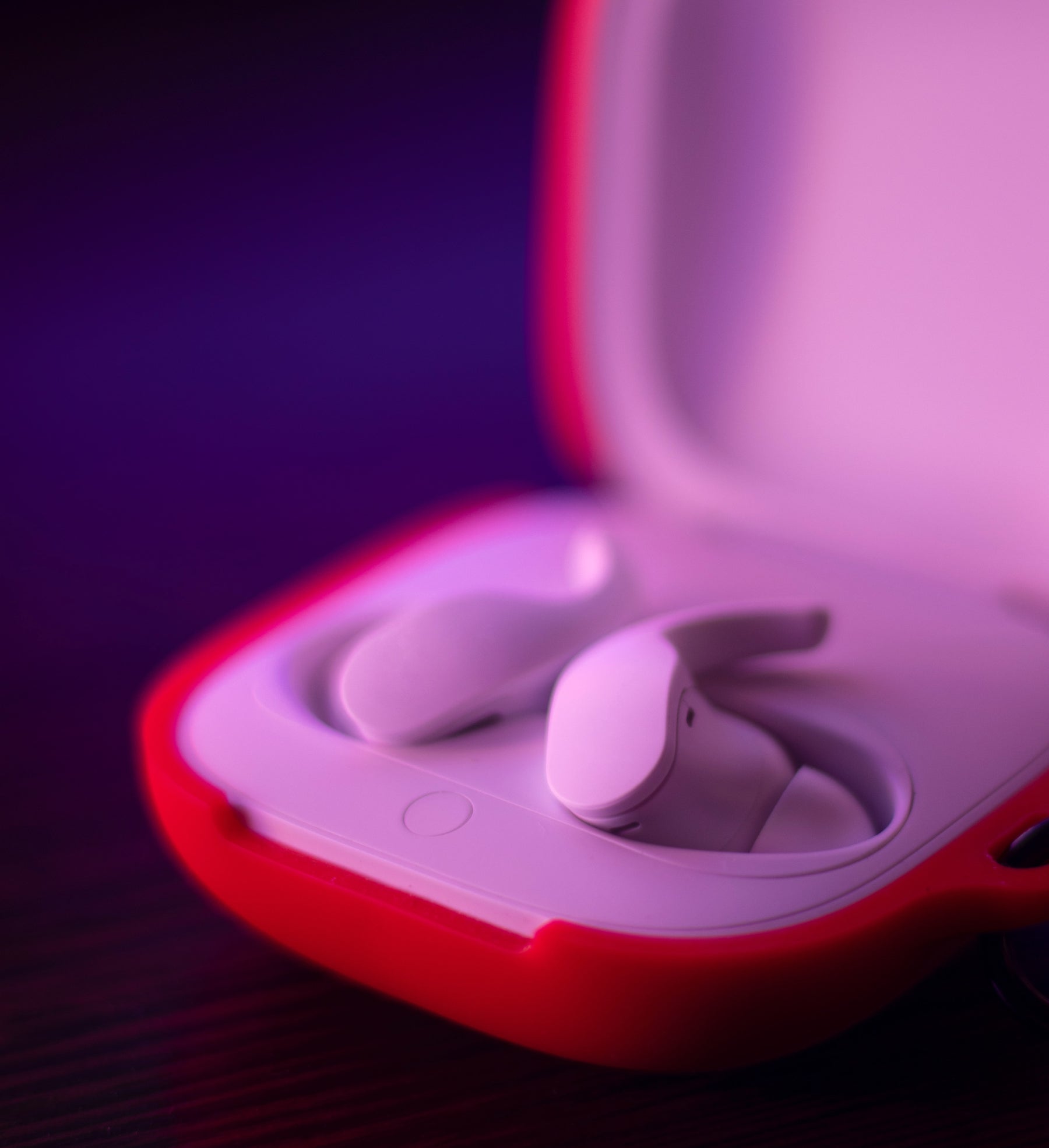 Two earbuds in an open red and white box